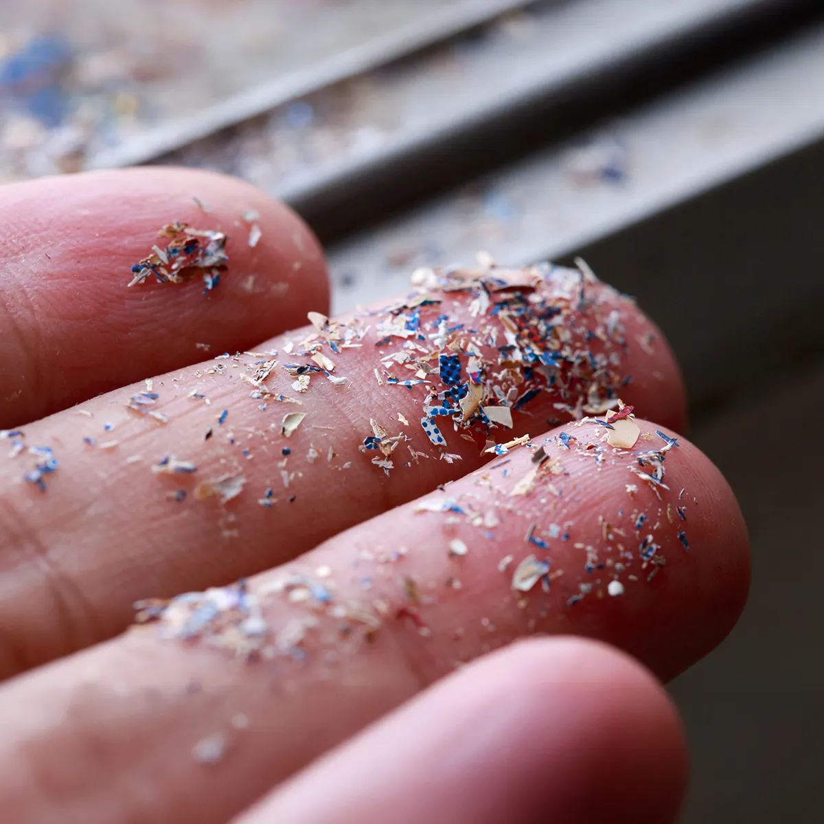 Fingertips covered in fragments of microplastic.