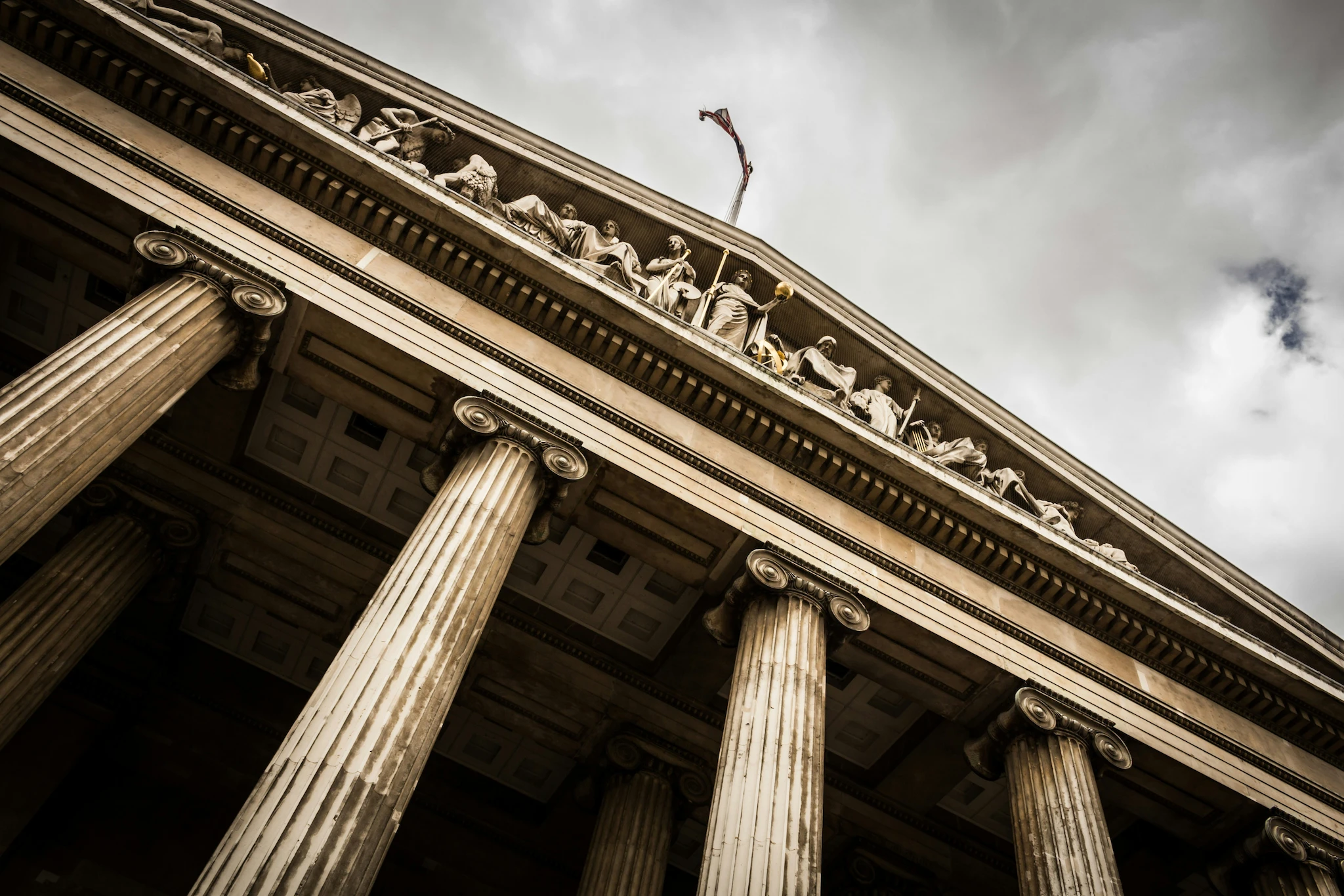 Looking up at the columns and carved pediment of a courthouse.
